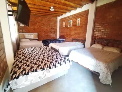 a room with two beds and a flat screen tv at Finca Lucía Kemper in San Vicente de Cañete