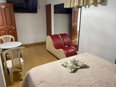 a room with a bed and a chair and a table at Princess Hotel in Supe