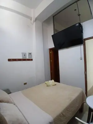 a bedroom with two beds and a television on the wall at Princess Hotel in Supe