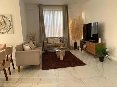 a living room with a couch and a tv at Topará Beach House in San Vicente de Cañete