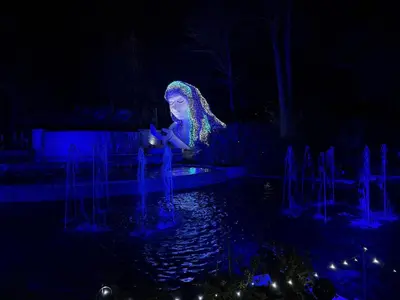 a woman sitting in front of a fountain at night at Topará Beach House in San Vicente de Cañete
