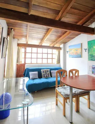 a living room with a blue couch and a table at Mini Apartment Flat in the heart of Cusco - Close to Main Square in Cusco