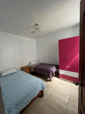 a bedroom with two beds and a pink cabinet at Departamento Playa El Silencio in Punta Hermosa