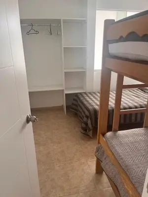 a small room with a bunk bed and a closet at Departamento 101 in Punta Negra