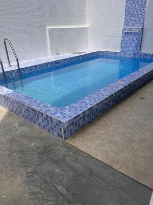 a swimming pool with blue tile around it at Departamento 101 in Punta Negra