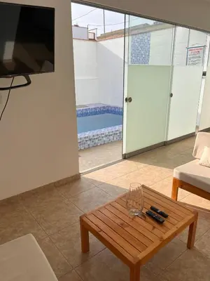 a living room with a coffee table and a tv at Departamento 101 in Punta Negra