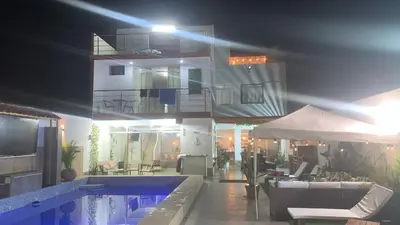 a building with a swimming pool at night at Casa pulpos in Punta Hermosa