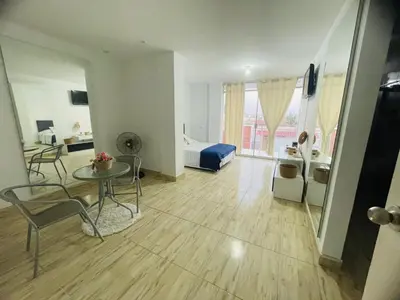 a living room with a bed and a table and chairs at Casa pulpos in Punta Hermosa