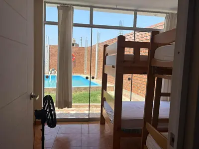 a bedroom with a view of a pool through a window at Casita de Playa 2026 in Supe