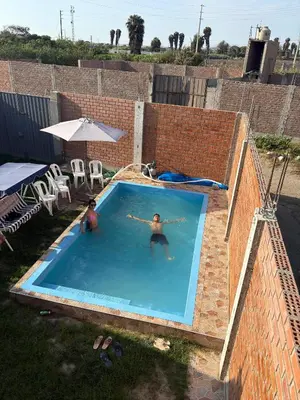 two people are swimming in a swimming pool at Casita de Playa 2026 in Supe