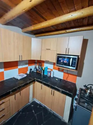 a kitchen with a sink and a microwave at Condomino Villa Andina in Urubamba