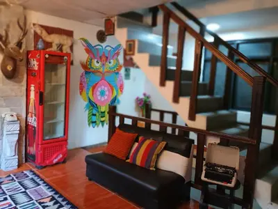 a living room with a couch and a staircase at Hostal Killari Machupicchu in Machu Picchu