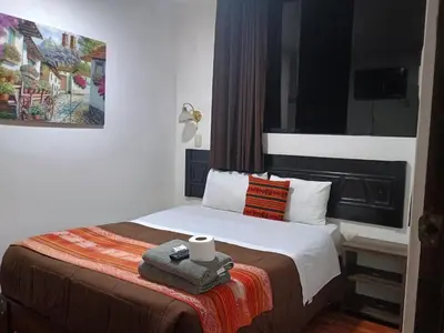 a bedroom with a bed with a candle on it at Hostal Killari Machupicchu in Machu Picchu