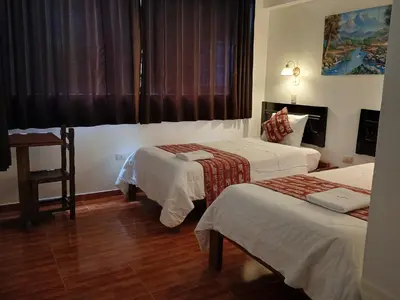 a hotel room with two beds and a window at Hostal Killari Machupicchu in Machu Picchu