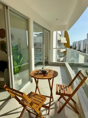 a balcony with a wooden table and two chairs at Oceanfront apartment con opcion de Velero in Paracas
