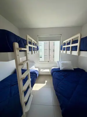 a room with two bunk beds and a ladder at Oceanfront apartment con opcion de Velero in Paracas