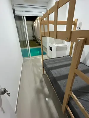 a room with a bunk bed and a ladder at CASA CERCA a PLAYA NAPLO CON PISCINA in Pucusana