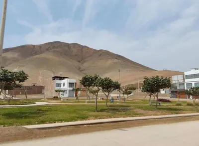 a large mountain in the background with trees and buildings at CASA CERCA a PLAYA NAPLO CON PISCINA in Pucusana