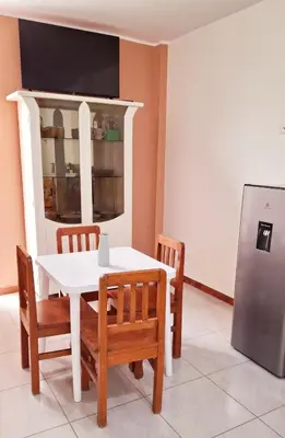 a dining room with a white table and chairs at Departamento independiente anexo a vivienda familiar in La Tinguiña