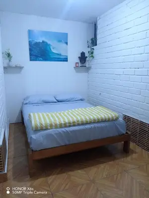 a bed in a room with a white brick wall at Mini Depa km 43 Punta hermosa in Punta Hermosa