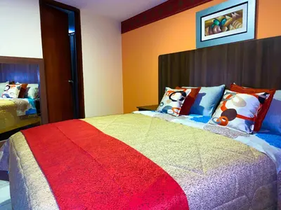 a bedroom with a large bed with colorful pillows at Hostal Mayra Breña in Lima