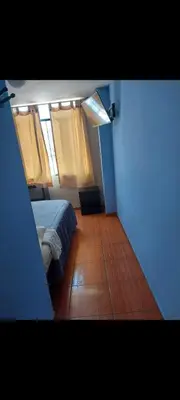a small bedroom with a bed and a window at Hospedaje Puerto Escondido in Pucusana