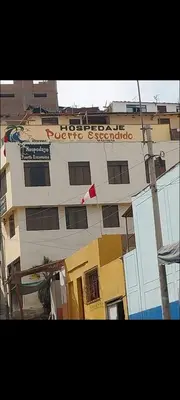 a building with a sign on the side of it at Hospedaje Puerto Escondido in Pucusana