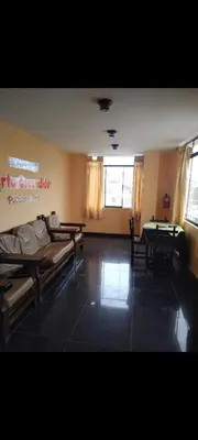 a room with a couch and a table and chairs at Hospedaje Puerto Escondido in Pucusana