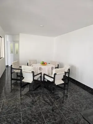 a dining room with a white table and chairs at Casa san Bartolo in San Bartolo