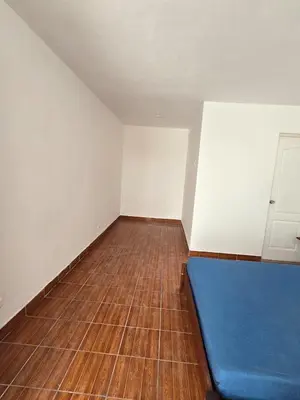 an empty room with a blue couch on a wooden floor at Casa san Bartolo in San Bartolo