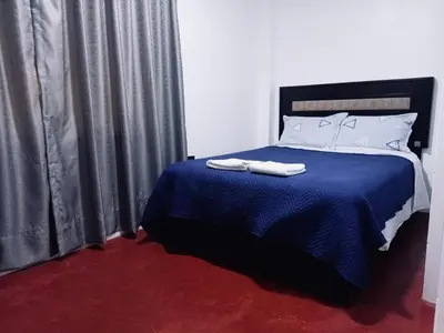 a bedroom with a blue bed with two towels on it at Habitación cama queen in Lima