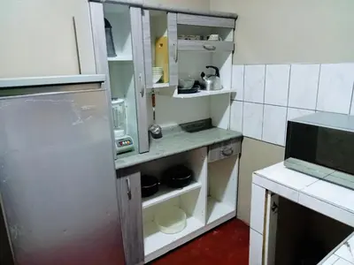 a kitchen with an open cabinet with dishes in it at Habitación cama queen in Lima