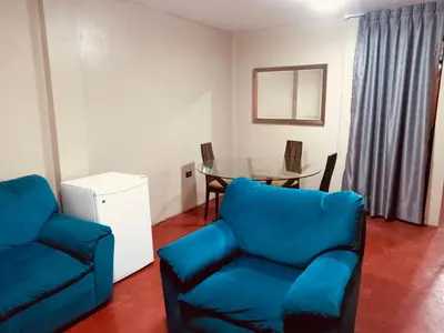 a living room with a blue couch and a table at Habitación cama dos plazas in Lima