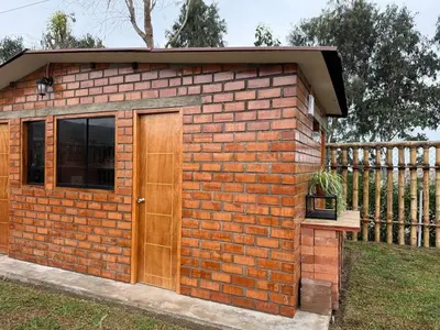 a brick building with a door and a fence at Casa Hacienda El Triangulo - Asia del Campo in Asia