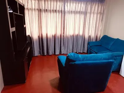 a living room with a blue couch and a window at Departamento de tres habitaciones amplio in Lima