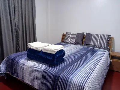 a bed with two towels on top of it at Departamento de tres habitaciones amplio in Lima