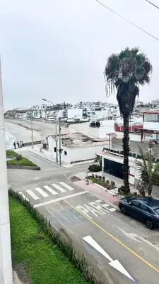 a street with a palm tree and a parking lot at Beach house in Punta Hermosa, central beach area in Punta Hermosa