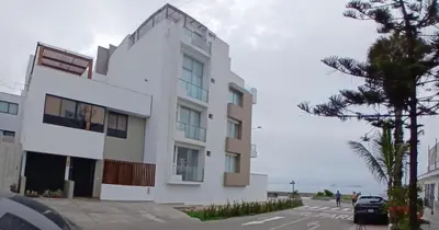 a white building with the ocean in the background at Beach house in Punta Hermosa, central beach area in Punta Hermosa