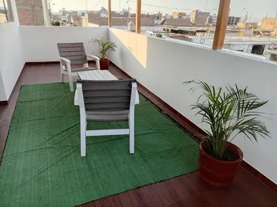 a balcony with two chairs and a green rug at Mary 2 in Paracas