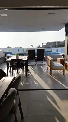 a patio with a table and chairs on a roof at Casa de Playa a 15min del boulevard de Asia in Cerro Azul