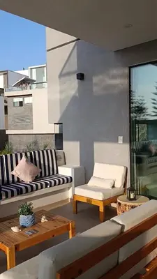 a living room with couches and tables on a balcony at Casa de Playa a 15min del boulevard de Asia in Cerro Azul