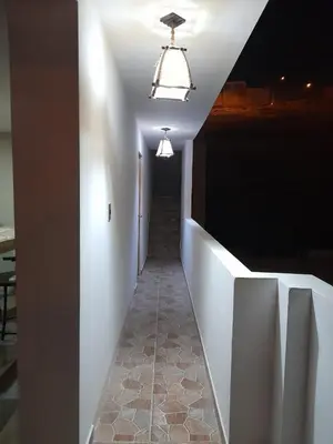 a hallway with a white wall and a light at Hospedaje Ocean Glips in Punta Negra