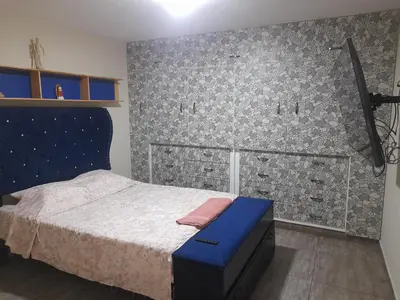 a bedroom with a bed with a blue headboard at Hospedaje Ocean Glips in Punta Negra