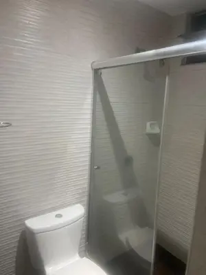 a bathroom with a toilet and a glass shower at Hotel Inkayacu Paracas Café in Paracas