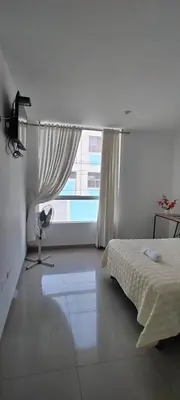 a white bedroom with a bed and a window at Hotel Inkayacu Paracas Café in Paracas