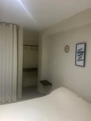 a bedroom with a white bed and a curtain at Hotel Inkayacu Paracas Café in Paracas