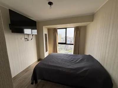 a bedroom with a bed and a large window at Modern apartment in Lima Surquillo in Lima