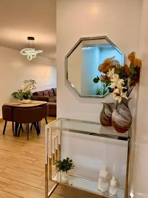 a glass shelf with two vases with flowers in a living room at seipoz in Lima