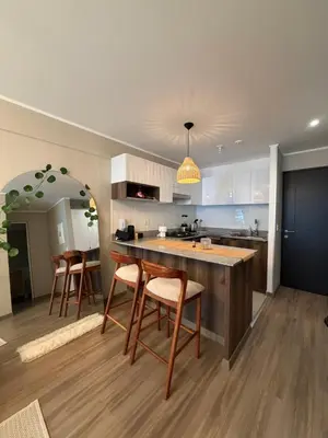 a kitchen with a counter and chairs in a room at Cozy apartment, downtown area, fully equipped in Lima