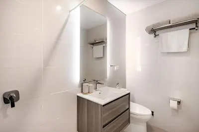 a bathroom with a sink and a toilet and a mirror at Bajada Balta Suites Spacious 3BR in Miraflores Walkable Area in Lima